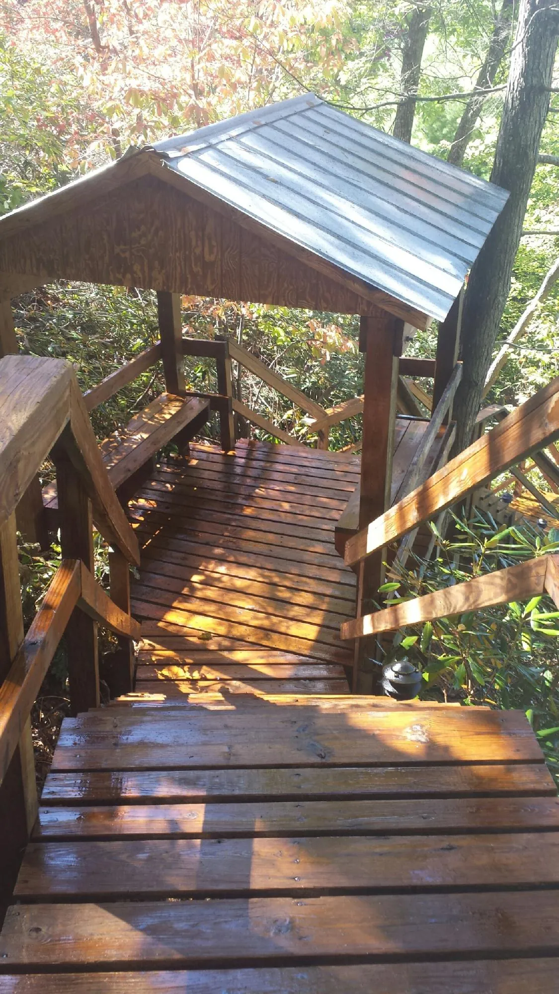 Freshly stained wood walkway and covered shelter with a metal roof in Anamoose